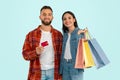 spouses posing with shopping bags and bank credit card, studio Royalty Free Stock Photo