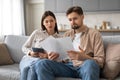 Spouses reviewing documents and using tablet at home Royalty Free Stock Photo