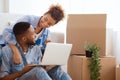 Spouses Using Laptop Computer Sitting On Sofa In New House Royalty Free Stock Photo