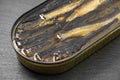 Sprats in oil, opened can of canned fish, on slate stone plate round, dark background selective focus Royalty Free Stock Photo