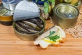 Sprats in open tin can, open sandwich against other cans