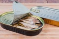 Sprats in partly open and sealed tin cans close-up