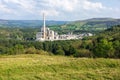 sprawling industrial complex amidst the serene countryside , stark contrast between nature and production