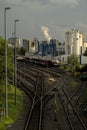 Sprawling industrial landscape in the background with railroad tracks and freight trains