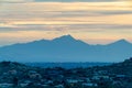 Sprawling mountain wilderness sunset with houses and homes in desert neighborhood with orange skies and blue clouds Royalty Free Stock Photo