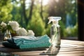 Spray bottle and towel on wooden table in garden, closeup