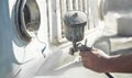 Spray gun in the hand of a painter. Painting car details Royalty Free Stock Photo