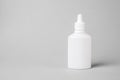 Spray for the nose in a white plastic bottle on a gray background. Aerosol from the common cold or allergy