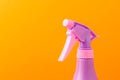 Spray nozzle on a bottle/purple spray nozzle on a bottle on a orange background. Copy space.