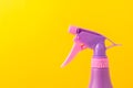 Spray nozzle on a bottle/purple spray nozzle on a bottle on a yellow background. Copy space