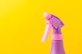 Spray nozzle on a bottle/purple spray nozzle on a bottle on a yellow background. Copy space