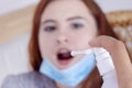 Spray for sore throat. Photo of woman who treats her throat with a spray and sprinkles it in her mouth.