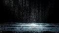 Spray spatters rain fall against on the water surface which glow. Black background. White neon lighting in dark studio