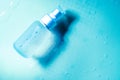 spray transparent bottle over blue background, cosmetics or body care product Royalty Free Stock Photo