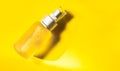 spray transparent bottle over yellow background, cosmetics or body care product Royalty Free Stock Photo