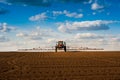 sprayer with long arms, fertilizer spreader that fertilizes farm fields view with beautiful clouds