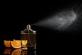 Spraying bottle of perfume and slices of citrus fruit