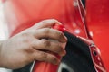 spraying grease on the car door mechanism at shallow depth of field