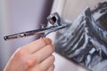 Spraying gun an air brush in female hand, painting mountains with aerograph, close up view Royalty Free Stock Photo