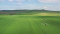 Spraying tractor with herbicides chemicals over young field