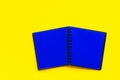 Spread of open blank black notepad with blue pages on bright yellow background. Trendy funky style vibrant colors. Business