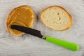 Spread on peanut butter with knife slice of bread on table. Top view Royalty Free Stock Photo