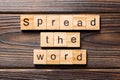 Spread the word word written on wood block. Spread the word text on table, concept