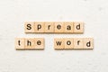 Spread the word word written on wood block. Spread the word text on table, concept