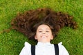 Spread your charm. Happy kid spread long wavy hair lying green grass. Back to school look. Hair salon. Hairdressing Royalty Free Stock Photo