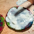 Spreading of cream on layer of colorful baked cake