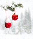 Sprig of christmas tree spruce with of hanging balls in snow in of winter fir forest during snowfall with space for text Royalty Free Stock Photo