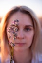 Sprigs purple lavender against background of blurred face of young blonde woman. Allergy concept Royalty Free Stock Photo