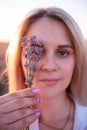 Sprigs purple lavender against background of blurred face of young blonde woman. Allergy concept Royalty Free Stock Photo