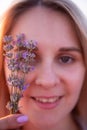 Sprigs purple lavender against background of blurred face of young blonde woman. Allergy concept Royalty Free Stock Photo