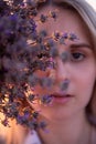 Sprigs purple lavender against background of blurred face of young blonde woman. Allergy concept Royalty Free Stock Photo
