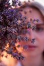 Sprigs purple lavender against background of blurred face of young blonde woman. Allergy concept Royalty Free Stock Photo