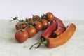 Sprigs of ripe cherry tomatoes and pods of sweet red chili pepper close up. High Key