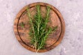 Sprigs of rosemary on a wooden round board. Flat lei.