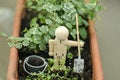 Spring activity in the garden with a wood mannequin, holding a shovel by a bucket full of soil