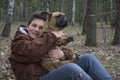 In the spring  a boy sits in the forest and holds a French Bulldog dog in his arms Royalty Free Stock Photo