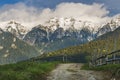 Spring alpine landscape with green fields and high snowy mountains,Bran,Transylvania Royalty Free Stock Photo