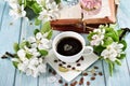 Spring apple blossoms and a cup of black coffee on blue wooden table Royalty Free Stock Photo