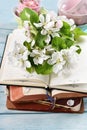 Spring apple blossoms and old books on blue wooden table Royalty Free Stock Photo