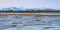 Spring arctic landscape. View of the river in the tundra, colorful buildings and mountains. Royalty Free Stock Photo