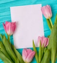 Spring background with bouquet of tulips and blank sheet of paper for romantic entries.