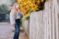 Spring background - flowers, white wooden fence, girl blurred in the background Royalty Free Stock Photo