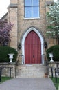 Beautiful red church door framed by flowering trees, spring time, Galena, IL.