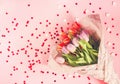 Spring beautiful tulip flowers on soft pastel pink background with red heart tinsel. Mother& x27;s day, greeting card festive Royalty Free Stock Photo