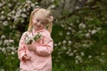 Spring blossom flowers for cute blonde child in flowering garden. Portrait of little child girl near blooming tree Royalty Free Stock Photo