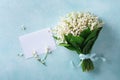 Spring bouquet of flowers lily of the valley and empty greeting card top view